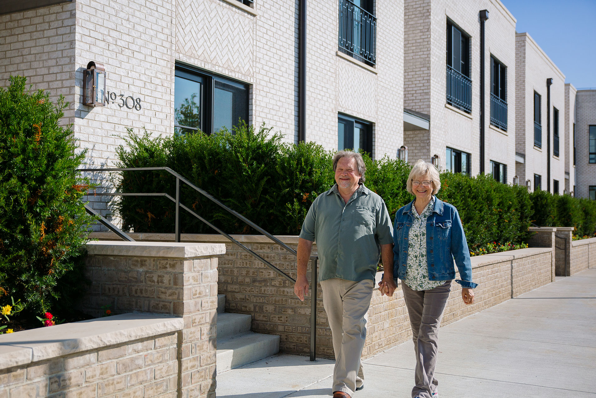 Two people walking past the leasing office for the delta.