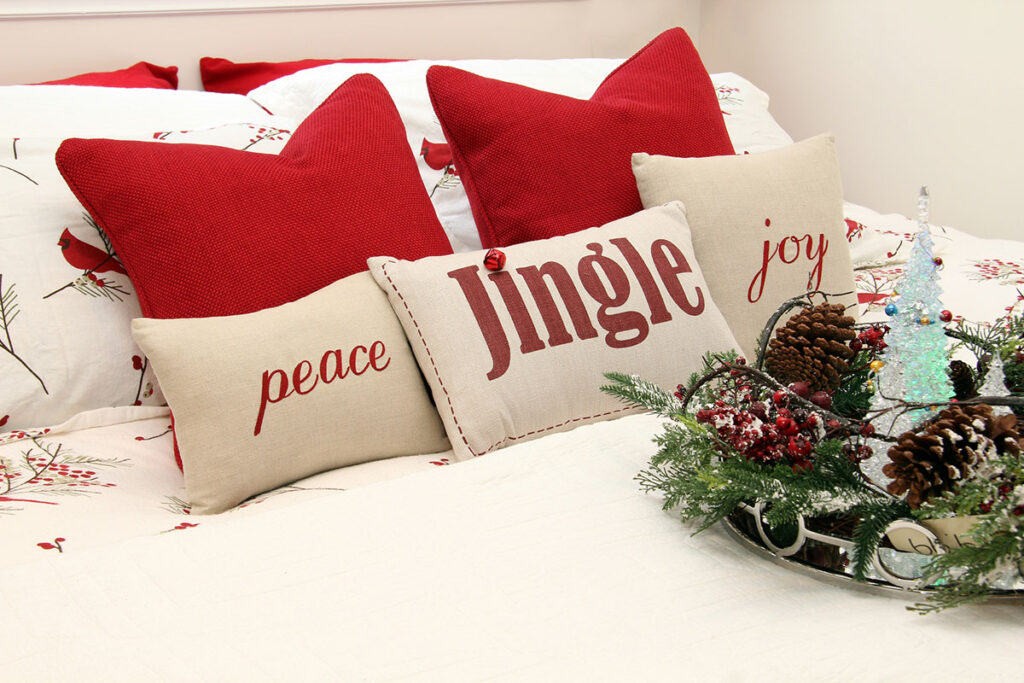 Christmas pillows and decorations on a bed 